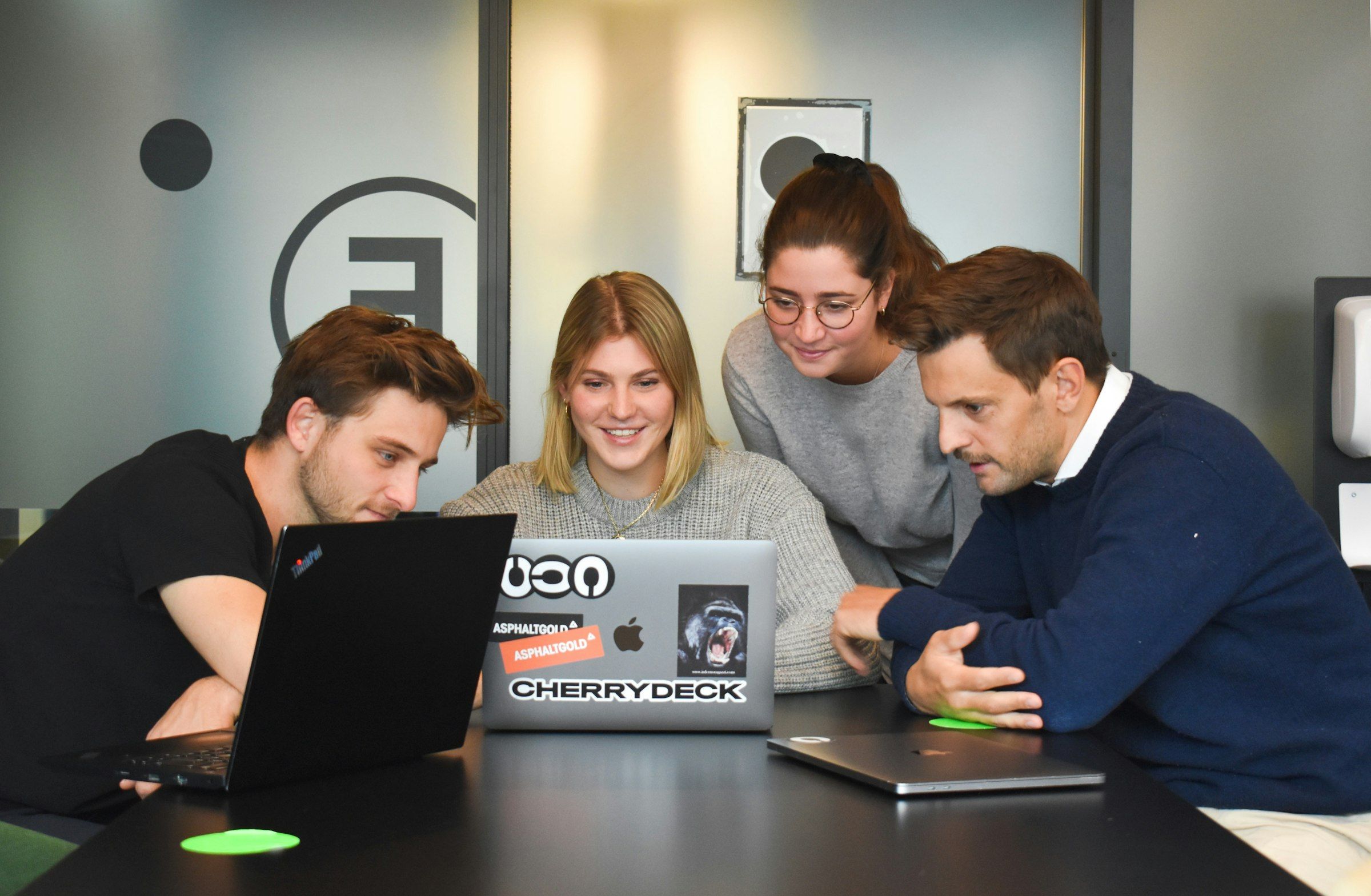 Quatre collègues autour d’un ordinateur portable dans un bureau